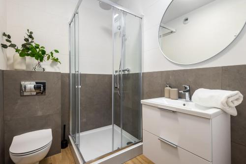 e bagno con doccia, servizi igienici e lavandino. di Apartamenty Jaworska 4 Wrocław a Breslavia