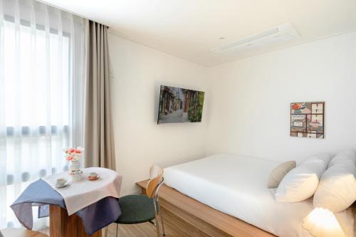 Habitación blanca con cama y mesa en Urbanstay Boutique Ikseon, en Seúl