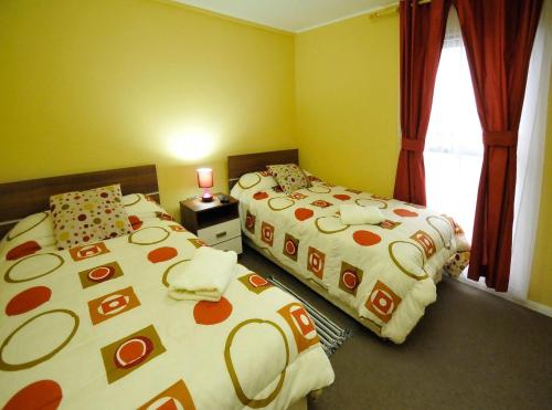1 Schlafzimmer mit 2 Betten und einem Fenster in der Unterkunft Alojamientos San Sebastián Talca in Talca