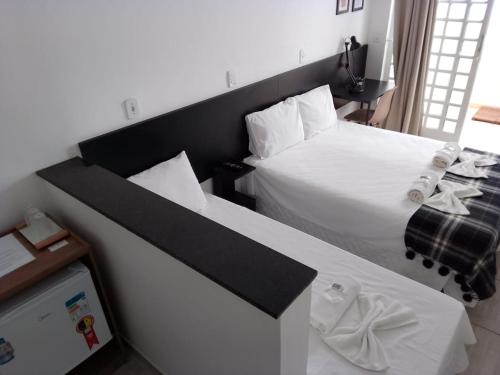 a bedroom with a large bed with a black headboard at Hotel Pousada Santa Maria in Aparecida