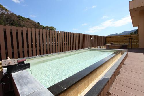 a large swimming pool with a wooden fence at Yugawara Chiyodasou in Yugawara