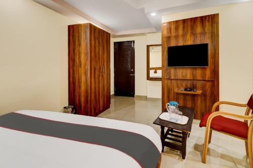 a hotel room with a bed and a tv at Collection O Hotel Hemadri Residency in Bangalore