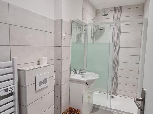 a white bathroom with a sink and a shower at Appartement Lacroix-sur-Meuse, 2 pièces, 2 personnes - FR-1-585-91 in Lacroix-sur-Meuse