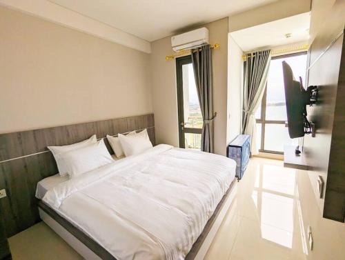 a bedroom with a large white bed and a television at Lovina 31-ABAC at One Residence in Batam Center