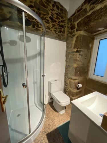a bathroom with a shower and a toilet and a sink at Casa do fundo do povo 