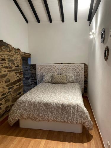a bedroom with a bed and a stone wall at Casa do fundo do povo 