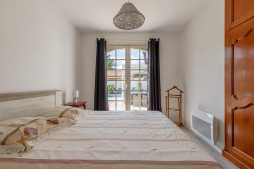 ein Schlafzimmer mit einem großen Bett und einem Fenster in der Unterkunft Villa Brétignolles in Brétignolles-sur-Mer