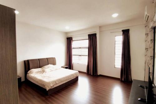 ein Schlafzimmer mit einem Bett und zwei Fenstern in der Unterkunft JJ Homestay -Stapok in Kuching