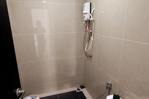 ein Bad mit einer Dusche und einem Telefon an der Wand in der Unterkunft JJ Homestay -Stapok in Kuching