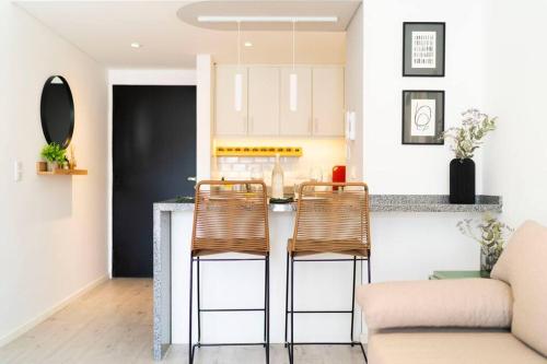 a kitchen and living room with a counter and chairs at Almagro BA Studio. in Buenos Aires