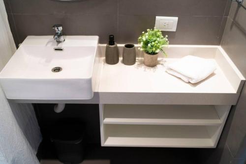 a bathroom with a white sink with flowers on it at Almagro BA Studio. in Buenos Aires