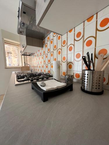 une cuisine avec un mur à motifs orange et blancs dans l'établissement Casa di Giovi, à Caltagirone