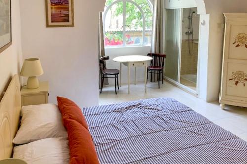a bedroom with a bed and a table and chairs at Bougainvillea Breeze & Marina View - Happy Rentals in Cospicua