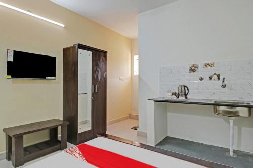 a room with a sink and a table and a tv at Flagship Gokul Residency in Bangalore