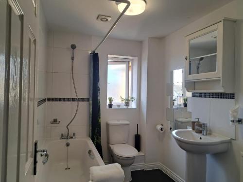 ein Badezimmer mit einem Waschbecken, einem WC und einer Badewanne in der Unterkunft Luxury Rooms In Furnished Guests-Only House Free WiFi West Thurrock in Grays Thurrock
