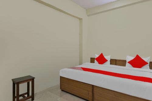 een slaapkamer met een bed met rode en witte kussens bij Flagship Hotel Loknath Inn in Chinhat