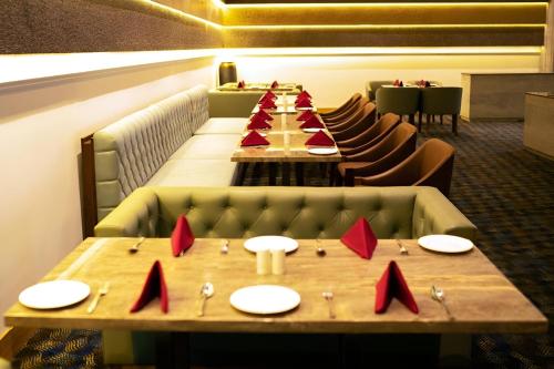a long dining room with a long table with red napkins at Ramada Plaza by Wyndham Jammu Vijaypur in Jammu