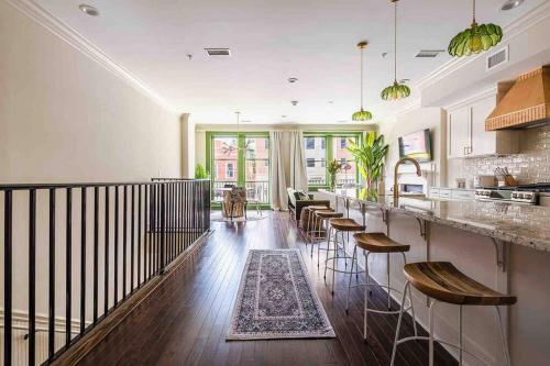 uma cozinha e sala de estar com um bar com bancos em Urban Oasis w/Sunroom-Downtown Columbia em Columbia