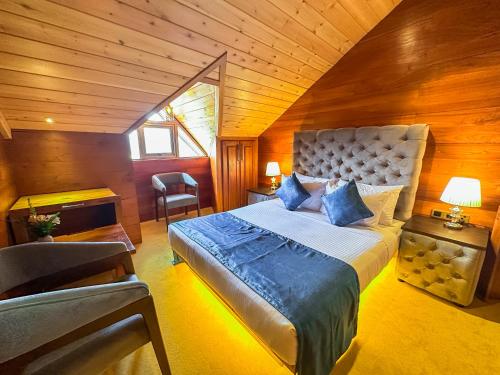 um quarto com uma cama grande num quarto de madeira em Baron Luxury Boutique em Nuwara Eliya