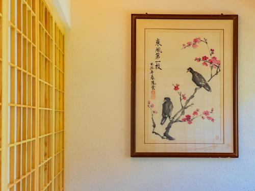 a framed picture of two birds on a tree branch at Joke Inn in Xi'an