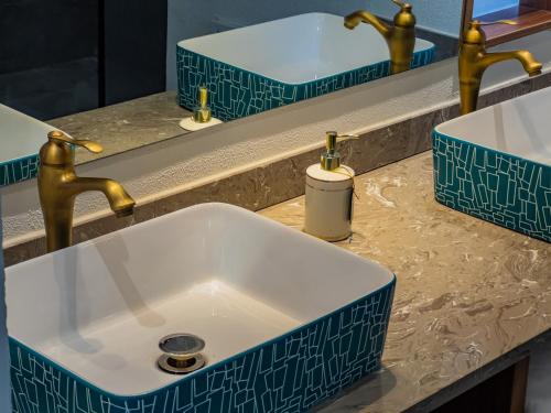 a bathroom sink with two faucets on a counter at Joke Inn in Xi'an