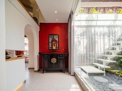 a hallway with a red wall and a stair case at Joke Inn in Xi'an
