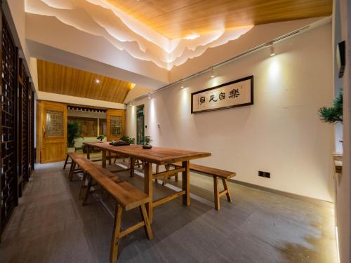 a dining room with a wooden table and benches at Joke Inn in Xi'an