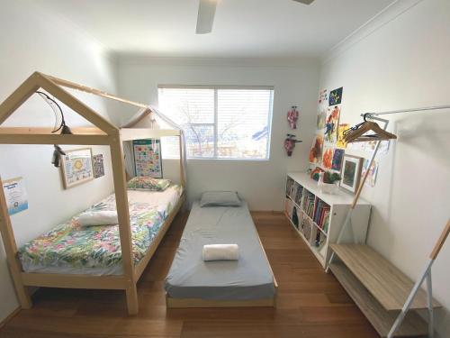 a bedroom with a bunk bed and a book shelf at Stylish and Spacious Beach Apartment in Sydney