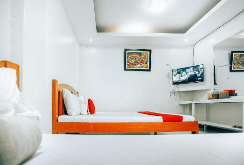 a bedroom with a bed with white walls at RedDoorz at S & L Apartelle Daraga Albay in Legazpi