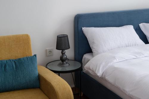 1 dormitorio con 1 cama y mesa auxiliar con lámpara en Gudauri Ski Resort - Alpic Mountain View Apartments, en Gudauri