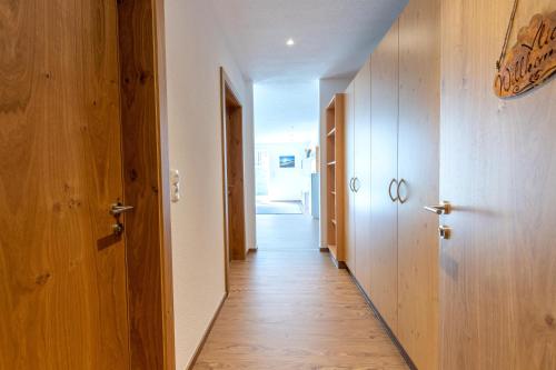 a hallway with wooden floors and wooden doors at Ferienwohnung Pedit in Tarrenz
