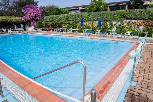 a large swimming pool with chairs in a hotel at 070 - Villa OLANDA con veranda VISTA MARE a 5 minuti SPIAGGIA con PISCINA CONDOMINIALE in Sestri Levante