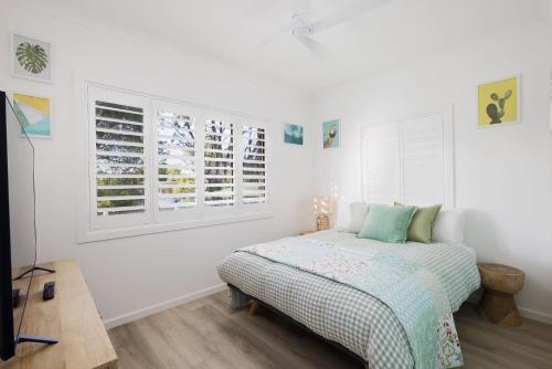 尼尔森湾Little Beach Boutique Apartment的一间白色卧室,配有床和2个窗户