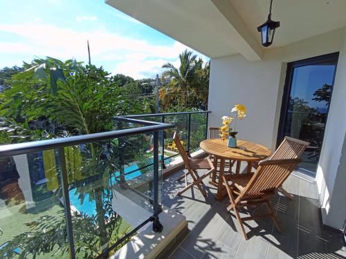 a balcony with a table and chairs and a pool at Résidence Amarosa in Les Avirons
