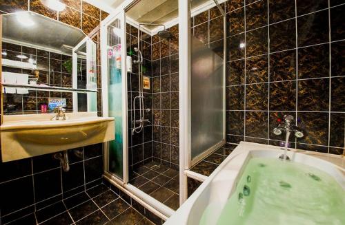 a bathroom with a green tub and a sink at Wen Sha Bao Motel-Xinying in Xinying