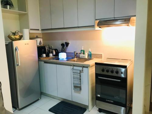a kitchen with a stainless steel refrigerator and a sink at One Bedroom with Netflix at Legaspi Village Makati in Manila