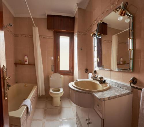 uma casa de banho com um lavatório, uma banheira e um WC. em Chez Pitu em Nofuentes