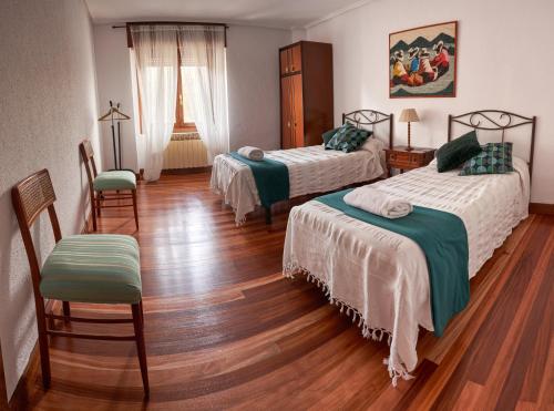 um quarto de hotel com duas camas e duas cadeiras em Chez Pitu em Nofuentes