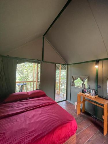 a bedroom with a large bed in a tent at Watersmeet Glamping in Deraniyagala