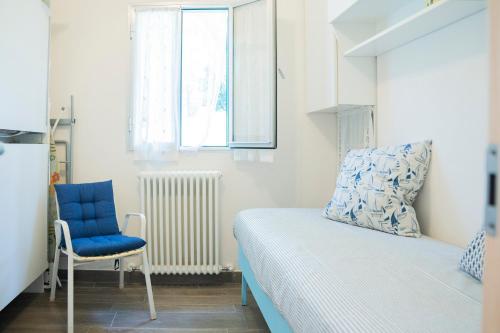 niewielka sypialnia z łóżkiem i niebieskim krzesłem w obiekcie 070 - Villa OLANDA con veranda VISTA MARE a 5 minuti SPIAGGIA con PISCINA CONDOMINIALE w mieście Sestri Levante