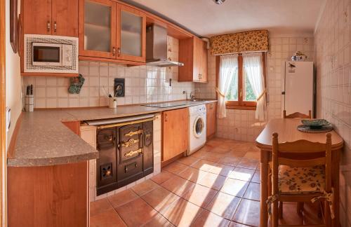 a kitchen with a stove and a sink and a refrigerator at El Mirador 2 in Paralacuesta