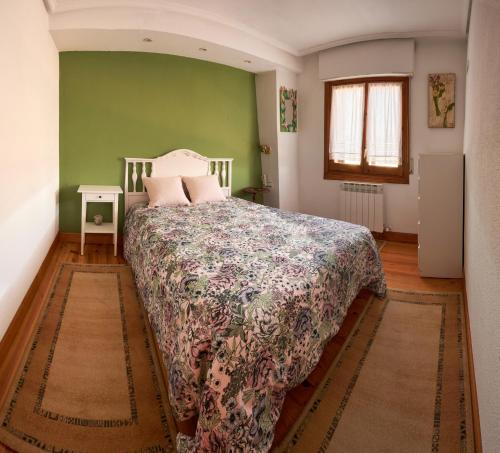 a bedroom with a bed and a green wall at El Mirador 2 in Paralacuesta