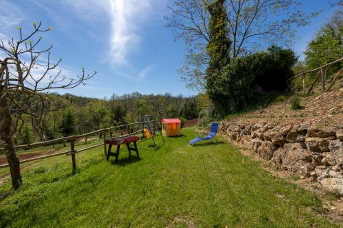 - une aire de jeux dans un champ à côté d'une clôture dans l'établissement Podere del Ciacchi Among Tuscany Greenery - Happy Rentals, à Montieri