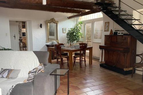 a living room with a table and a dining room at La Jas, demeure climatisée au charme gardois. in Nages-et-Solorgues