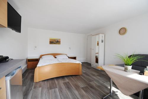 ein Schlafzimmer mit einem Bett, einem Tisch und einem Schreibtisch in der Unterkunft Bernsteinbäder Zimmer in Ostseebad Koserow