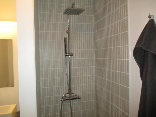 a shower with a shower head in a bathroom at White House Hotel Apartments in Brande