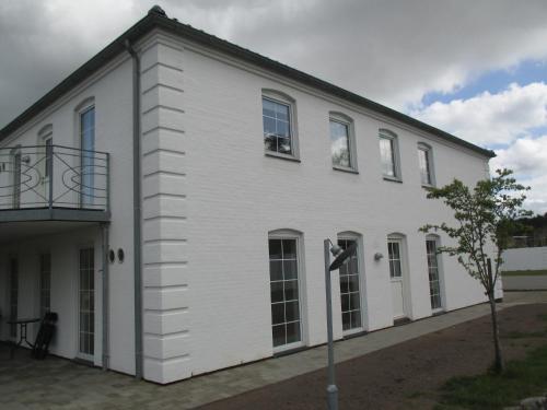 a white building with a balcony on the side of it at White House Hotel Apartments in Brande
