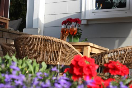 two chairs and a table with flowers on a porch at Hotel am Kurpark in Bad Lauterberg