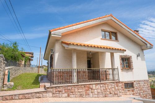 een klein wit huis met een balkon bij Casa en Llanes cerca de la playa, Niembru. El Carrascal in Llanes