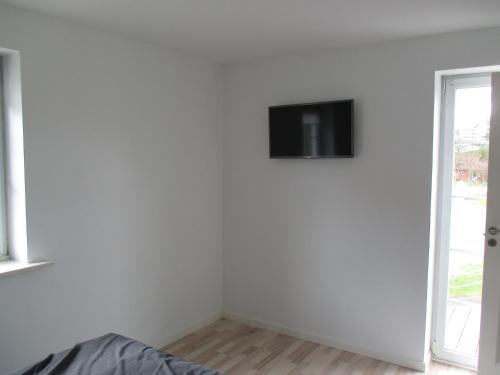 a white room with a tv on the wall at White House Hotel Apartments in Brande